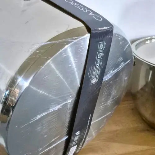 high quality Stainless steel cooker with a black handle and visible brand name on a wooden surface.