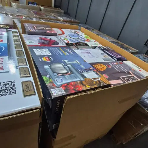 Stack of household wholesale product boxes with colorful packaging and visible brand logos.