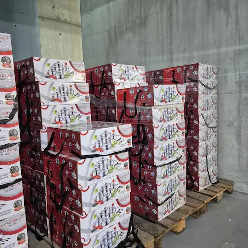 Stack of boxes with festive design on a pallet against a concrete wall.