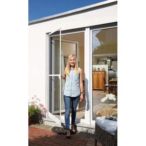 Woman standing in a modern home with an insect screen door